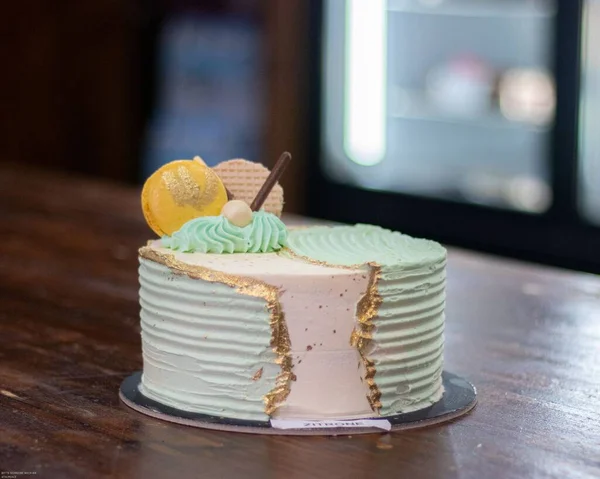 木のテーブルの上に緑とピンクのクリームケーキ — ストック写真