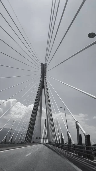 Pionowe Ujęcie Skali Szarości Mostu Kablowego Charilaos Trikoupis Pustą Autostradą — Zdjęcie stockowe