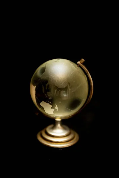 Een Verticaal Shot Van Een Kleine Globe Zwarte Achtergrond — Stockfoto