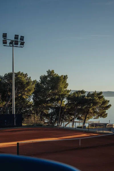 克罗地亚马卡斯卡海岸的一个网球场和绿树的垂直照片 — 图库照片