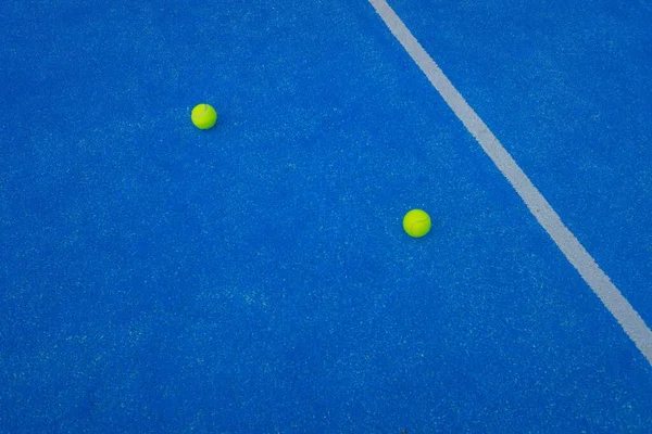 在靠近中心线的蓝色人造草场上的两个桨网球 羽毛球网球场 — 图库照片