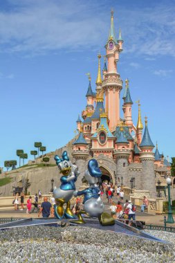 Fransa 'nın başkenti Paris' te Donald Duck ve Papatya Ördeği heykelinin arkasındaki peri masalı şatosuyla Disneyland 'e dikey bir bakış açısı.