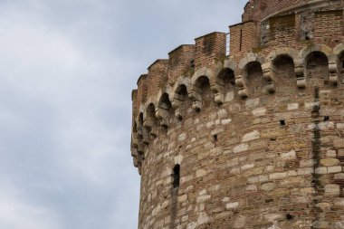 Arka planda mavi gökyüzü olan eski bir taş kuleye yakın çekim.