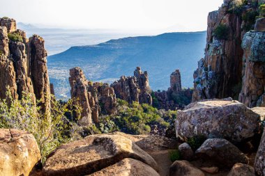 Arka planda dağ zirveleri olan taş oluşumlarının manzaralı görüntüsü