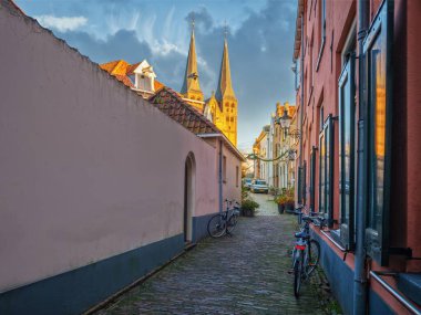 Deventer 'daki dağdaki kilise park halindeki bisikletlerle dar bir caddenin arka planında beliriyor.
