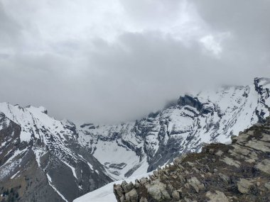 Kanada Alberta 'da karla kaplı dağın üzerinde bulutlu bir gökyüzünün güzel bir manzarası..