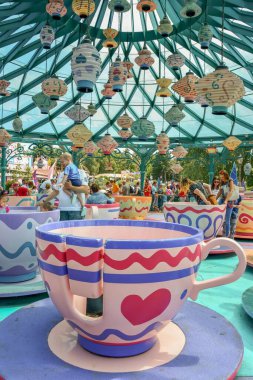 Mad Hatter 's Tea Cups' ın Disneyland, Paris, Fransa 'daki atlıkarıncalarından keyif alan güzel bir fotoğraf.