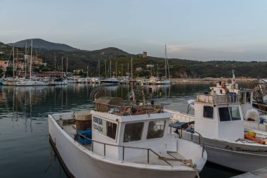 Günbatımında Marina di Camerota limanına park etmiş balıkçı teknelerinin görüntüsü.