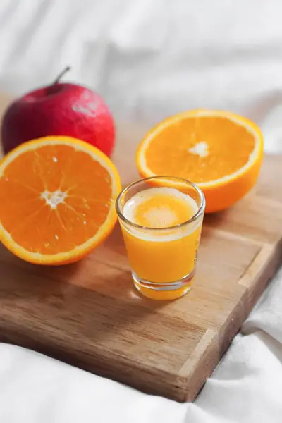 Egy Közeli Kép Vágott Narancsból Narancslével Almával Fedélzeten Fehér Ágyon — Stock Fotó