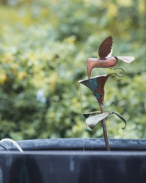 伍德兰花园一个小型水泉顶上一只青铜蜂鸟的垂直特写 — 图库照片