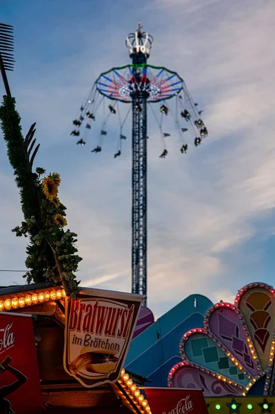 オクトーバーフェストの祭りの間にミュンヘンの遊園地で大きな乗り物の垂直ショット — ストック写真