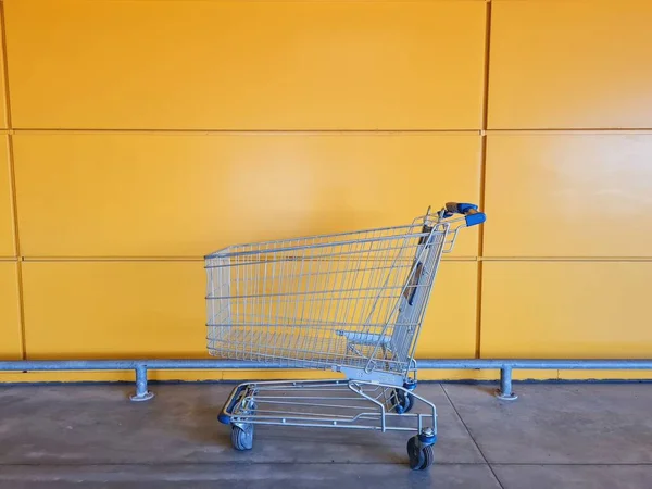 Primer Plano Carrito Compras Vacío Cerca Una Pared Amarilla Moderna — Foto de Stock