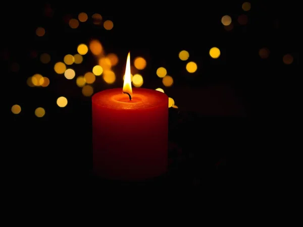 在黑暗的Bokeh背景上 一张燃烧的红色蜡烛的特写照片 — 图库照片