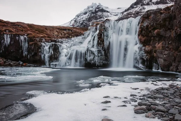 冰岛冬季结冰瀑布的风景画 具有丝滑的水效果 — 图库照片
