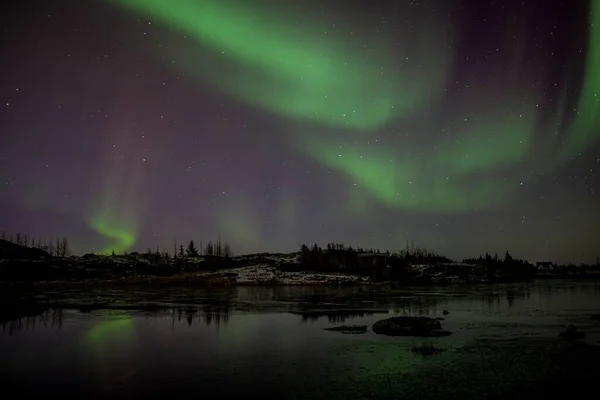 夜間にアイスランドの湖に反射するオーロラの風光明媚なショット — ストック写真