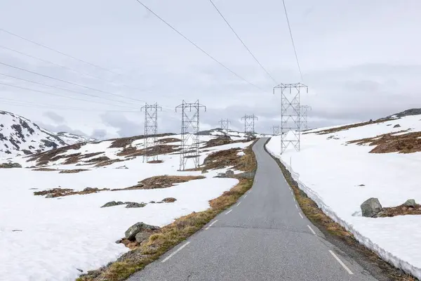 ノルウェー ティンデヴェンの雪原近くの長いアスファルト道路 — ストック写真