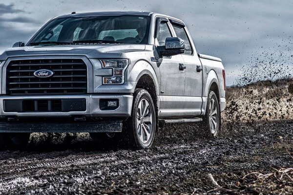 The Ford F150 Silver Truck Car 4x4 SUV driving in the mud