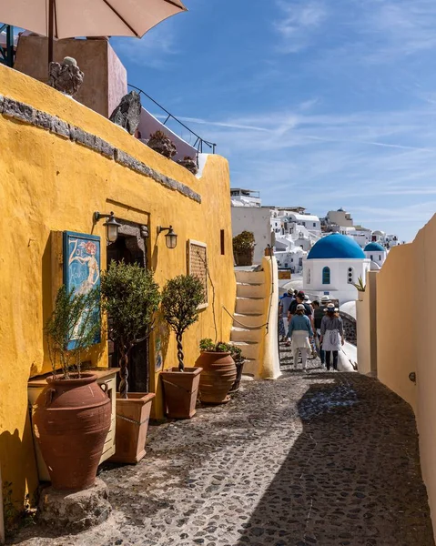 stock image A group of people walking on an alley in Oia village on a sunny day