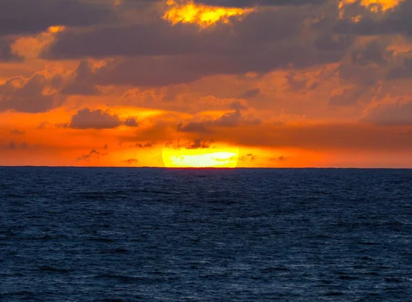 Ein Wunderschöner Leuchtend Orangefarbener Sonnenuntergang Über Einer Dunkelblauen Meeresoberfläche — Stockfoto