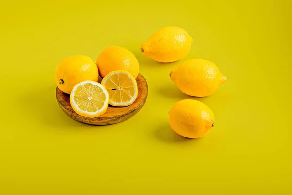 Крупный План Ломтиков Лимонов Несколько Целых Лимонов Деревянной Доске Желтым — стоковое фото