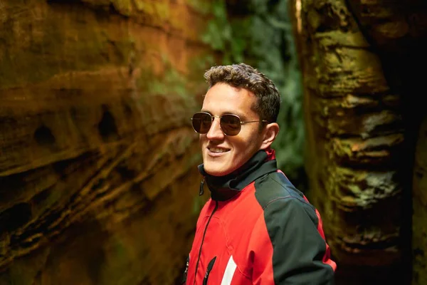 Hispánec Slunečními Brýlemi Usmívá Stojí Mezi Jeskyněmi — Stock fotografie