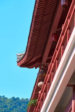 Mavi gökyüzünün altında kırmızı duvarları olan geleneksel Çin mimari ön cephe tapınağının bir kenarı.