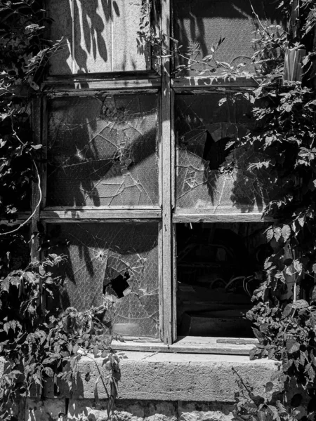 Graustufenaufnahme Eines Zerbrochenen Glasfensters Eines Alten Hauses — Stockfoto