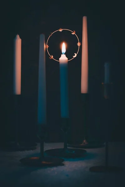 Vertikální Záběr Zapálené Svíčky Stole Zářícím Tmě — Stock fotografie