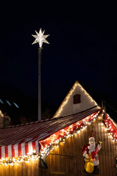 Вертикальный Снимок Деревянного Дома Украшенного Огнями Звездой Игрушкой Санта Клауса — стоковое фото