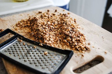 Tahta bir mutfak tahtasında rende ve tahıl gevreği..