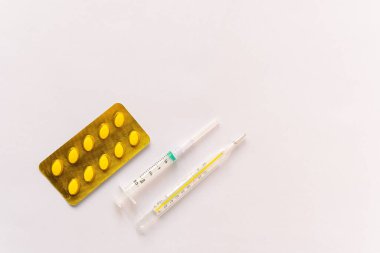 Çeşitli tıbbi ekipmanlar, termometre, ampuller, boru, uyuşturucu, tabletler, kapsüller, sprey, yama, şırınga, beyaz arka planda şişeler. İlaç.,