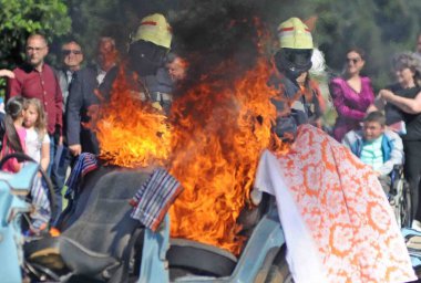 İtfaiyeciler sokakta yanan bir arabayı söndürdüler.