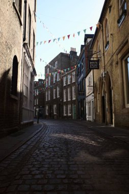 Green Street, Cambridge, İngiltere 'deki binalar arasında Bunting ile dar bir caddenin dikey çekimi.