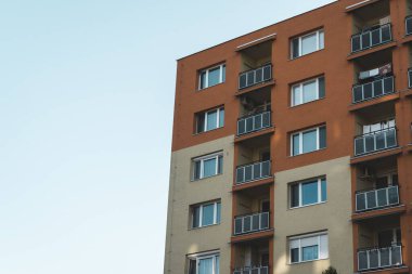 Gündüz vakti kremalı, kahverengi renkli ve balkonlu apartman manzarası.