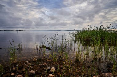 Bulutların altında deniz manzaralı güzel bir kaya görüntüsü.