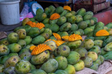 Sokak pazarında bir yığın taze mango meyvesi