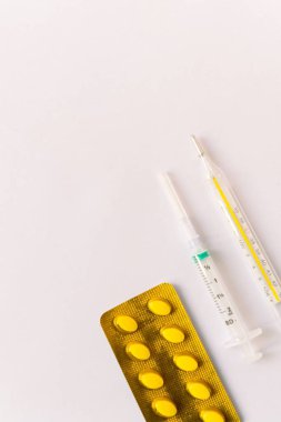 Çeşitli tıbbi ekipmanlar, termometre, ampuller, boru, uyuşturucu, tabletler, kapsüller, sprey, yama, şırınga, beyaz arka planda şişeler. İlaç.,