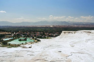 Orman tepelerindeki bir şehrin arka planındaki beyaz teraslar.