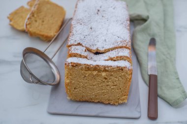 Vanilyalı sünger kekin yakın plan resmi. Üstünde krema şekeri var.
