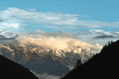 Bulutların altında dağlar olan güzel bir manzara.