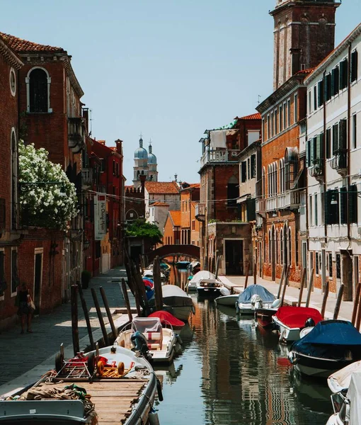 Pionowe Ujęcie Kanału Wenecji Włochy Wieloma Łodziami Zaparkowanymi Nim Słoneczny — Zdjęcie stockowe