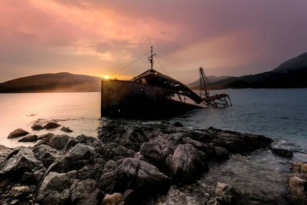 日没時に海の海岸で溺れた古い船のシルエット — ストック写真