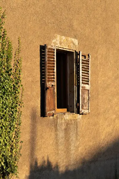 シャッター付きの古い窓のある放棄された建物の垂直ショット — ストック写真