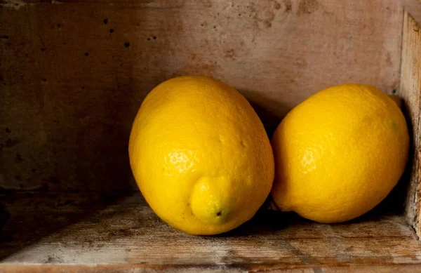 Tiro Close Dois Limões Amarelos Brilhantes Colocados Uma Prateleira Madeira — Fotografia de Stock