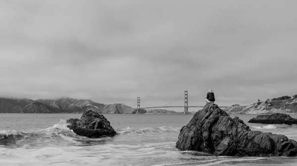 Женщина Сидящая Большом Камне Пляже Наслаждаясь Прекрасным Видом Мост Золотые — стоковое фото
