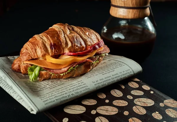 Een Close Shot Van Een Croissant Sandwich Een Krant — Stockfoto