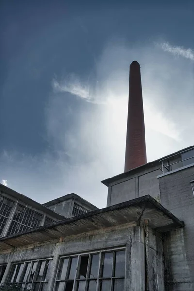 曇った空に対して煙突を持つ古い放棄された発電所の垂直ショット — ストック写真