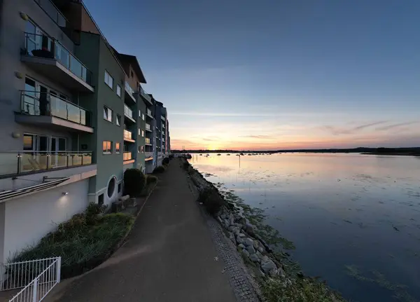 Göl Kıyısındaki Binalar Yollar Mavi Gölgeli Günbatımı Gökyüzünün Önünde — Stok fotoğraf