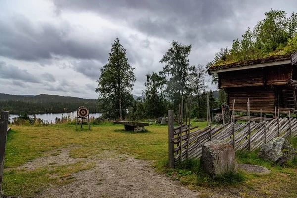 湖畔の森の中の木造塀に囲まれた素朴な家 — ストック写真
