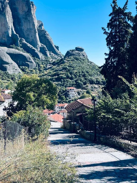 Dar bir yolun dikey görüntüsü dağın yamacındaki bir kasabadan geçiyor.